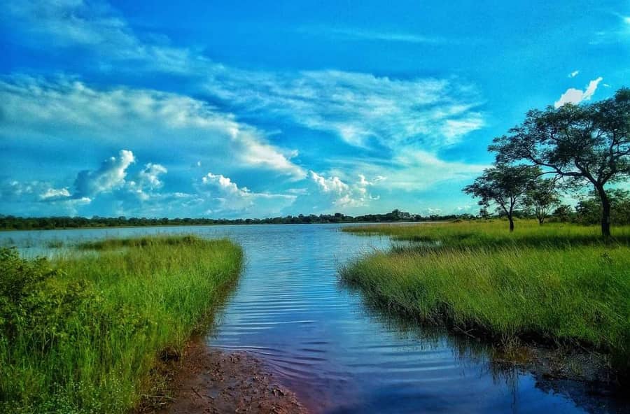 Un ciel bleu chargé de nuages au-dessus d'un plan d'eau, dans le nord du Ghana : le ciel dont parle le proverbe.