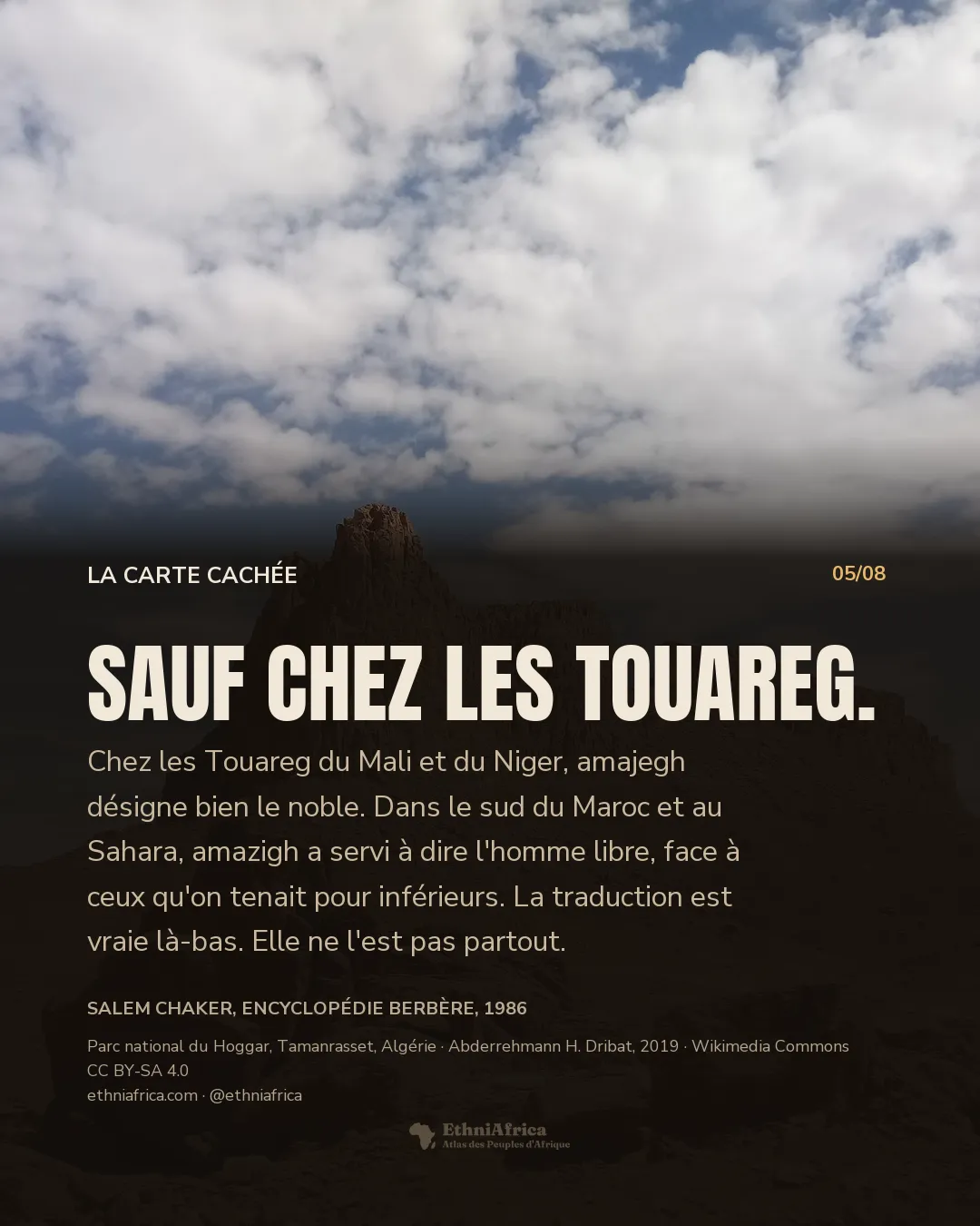 un massif rocheux isolé se dressant au milieu d'un désert de pierres, sous un ciel chargé de nuages