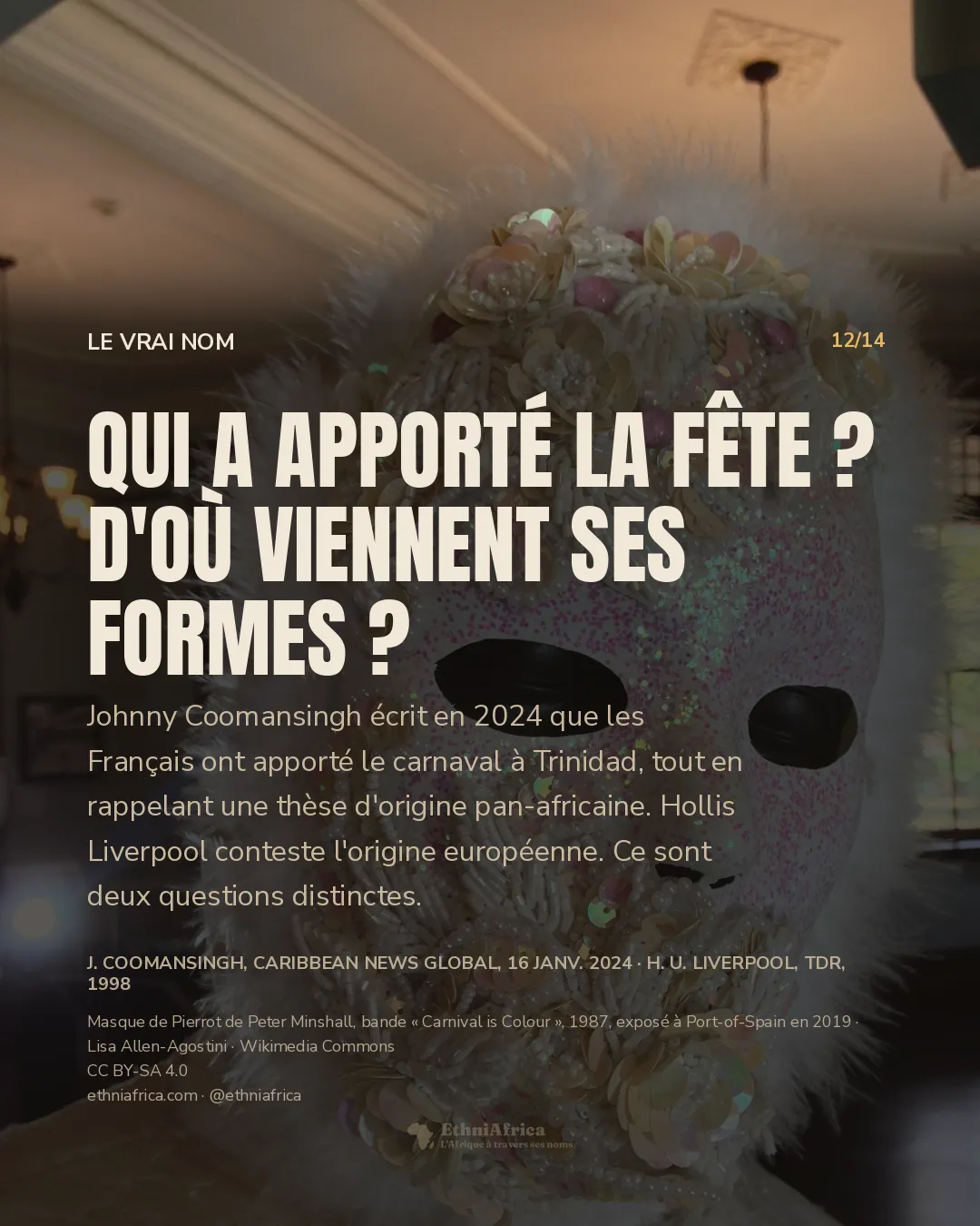 Un masque blanc couvert de perles, de sequins nacrés et de fleurs de perles, bordé de plumes blanches, posé sur un mannequin dans une salle aux moulures claires.