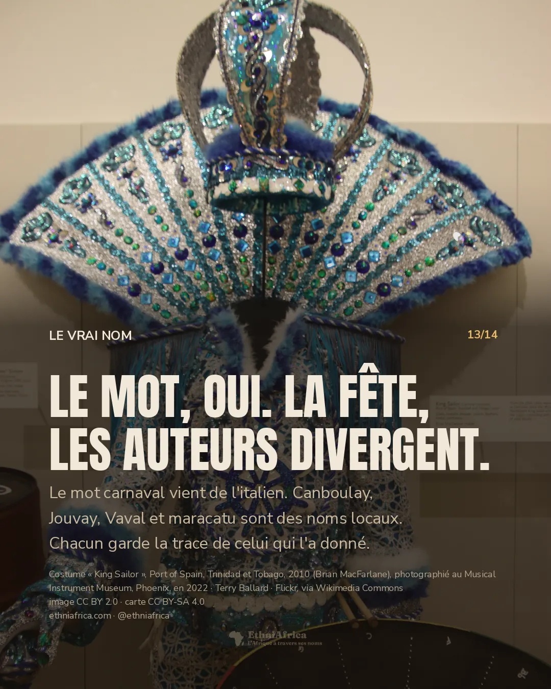 Un costume de carnaval sur mannequin sans visage : tunique de paillettes turquoise et argent, éventail rayonnant de plumes bleues, couronne, gouvernail brodé sur la poitrine ; un tambour d'acier au premier plan, en bas.